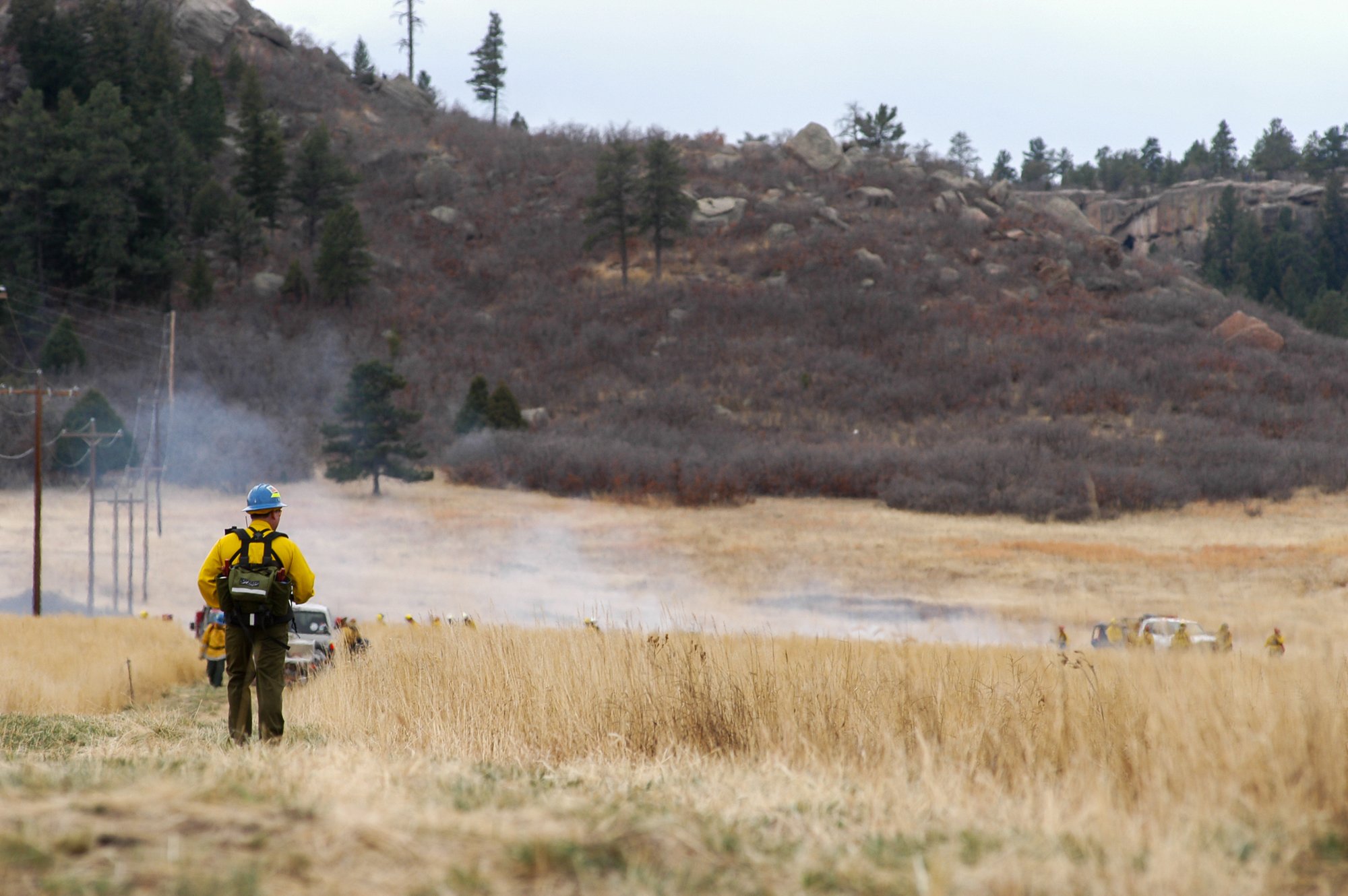 Wildfire professional in protective gear observing a prescribed burn in Franktown, Colorado