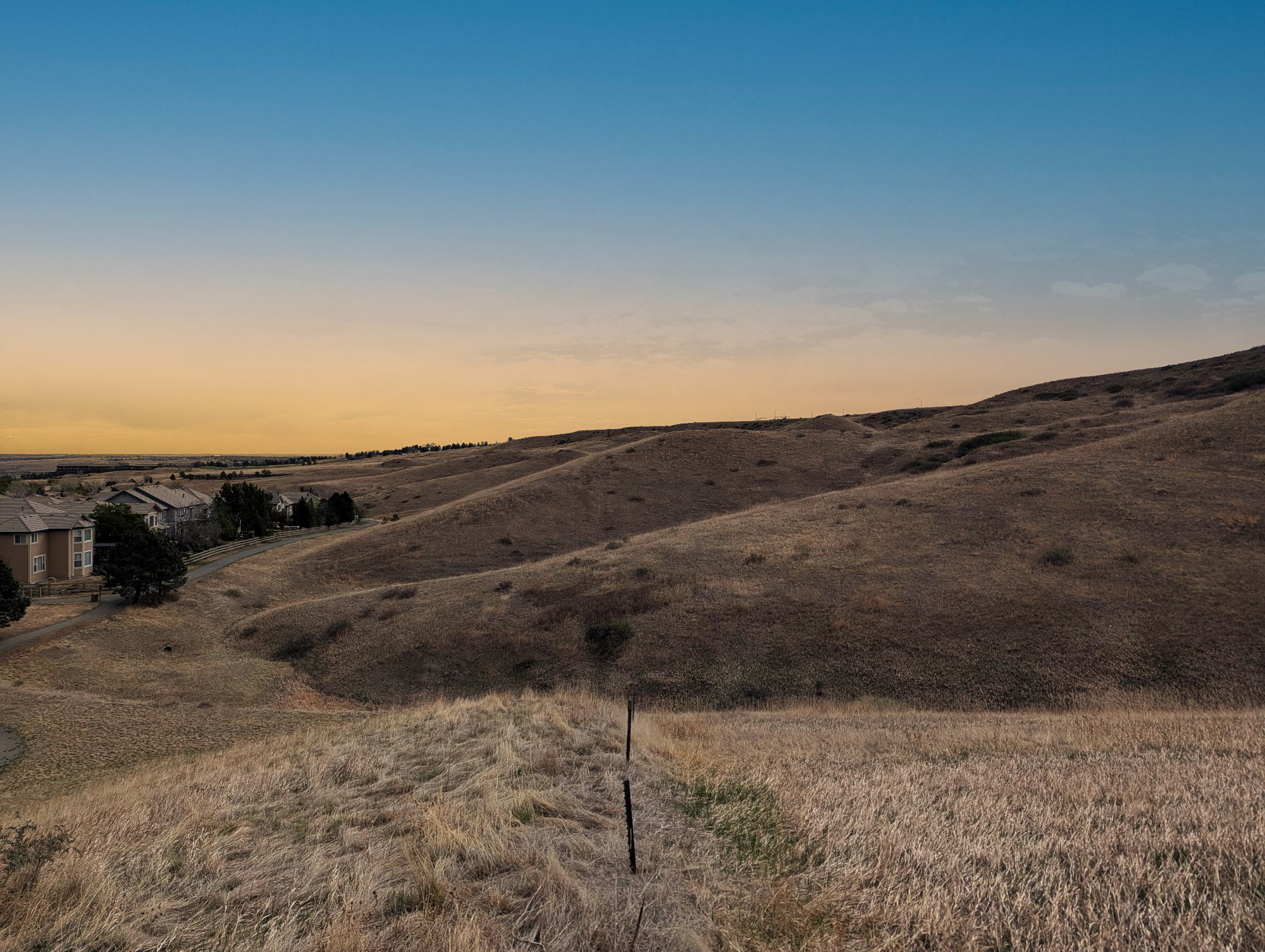 Bintel team conducting a wildfire risk assessment in a wildland-urban interface area in Colorado, showing dry grassland hills adjacent to residential homes.
